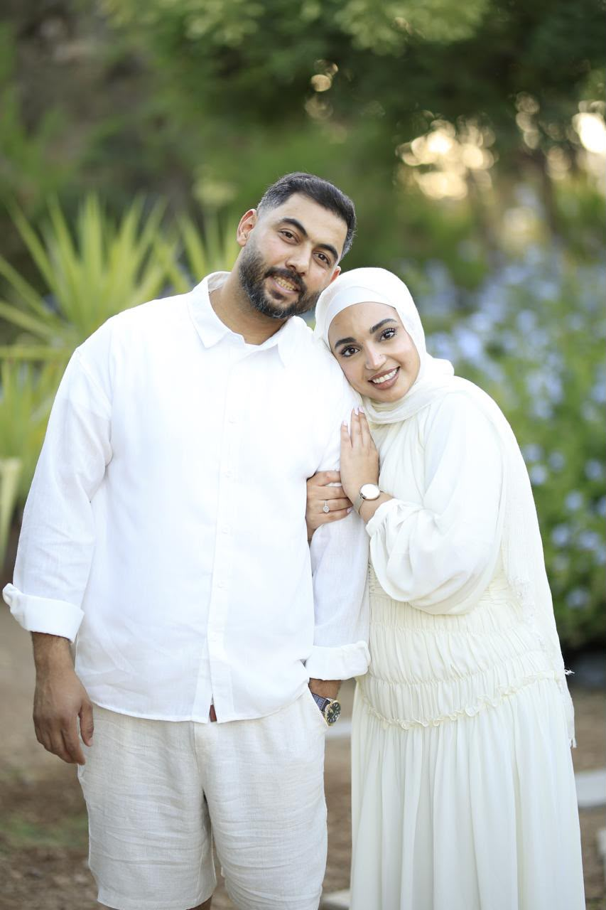 Basel and Rafeef smiling closely together in the garden
