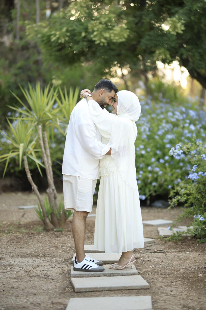 Basel and Rafeef embracing among the flowers